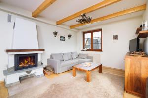 a living room with a couch and a fireplace at Apartments Osada Gubałówka Zakopane by Renters in Zakopane