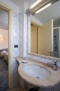 uma casa de banho com um lavatório e um espelho grande em Hotel Poseidon em Terracina