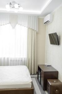 トムスクにあるMonomakh | Hotelのベッドルーム1室(ベッド1台、壁掛けテレビ付)