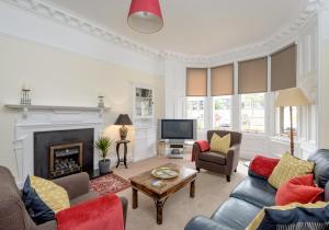 a living room with couches and a fireplace at The Lauderdale Street Residence in Edinburgh