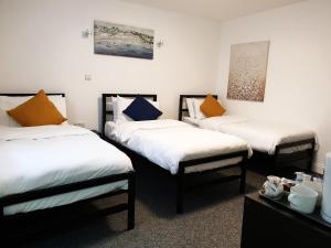 a hotel room with two beds and two nightstands at Wanstead Hotel in London