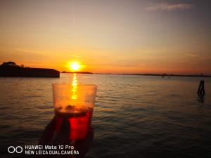 a drink with the sunset in the background at Cà ARIVANLIAL Venice villa apartament in Venice-Lido