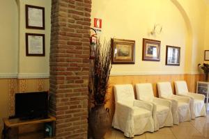 a row of white chairs in a waiting room at Hotel Hollywood in Rome