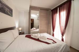 a bedroom with a bed with white towels on it at Stefanos Family Apartments in Moírai
