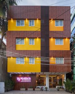 a yellow building with a sign in front of it at Regenta Inn Indiranagar by Royal Orchid Hotels in Bangalore