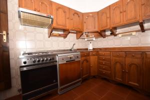 a kitchen with wooden cabinets and a stove top oven at Villetta Palombaia in Marina di Campo