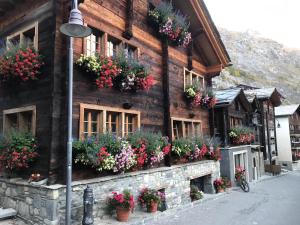 un edificio con cajas de flores en su lado en Chalet Schuler en Zermatt