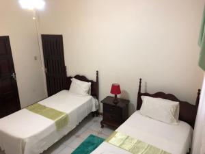 1 dormitorio con 2 camas y una lámpara roja en una mesa en GoldenView Guesthouse Ocho Rios, en Ocho Ríos