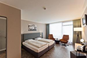 a hotel room with a bed and a desk at Arthotel ANA Neotel in Stuttgart