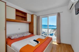 a bedroom with two beds and a view of the ocean at Apartments Ferdo in Živogošće