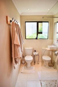 łazienka z toaletą, umywalką i oknem w obiekcie 10 On Ou Kraal w mieście Edgemead