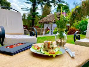 a plate of food on a table with a laptop at Mambo Hideaway in Arusha