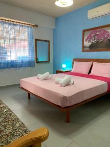 Zóla的住宿－B＆D1號公寓，一间卧室配有一张带粉红色床单的大床