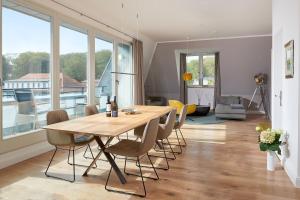 ein Esszimmer mit einem Holztisch und Stühlen in der Unterkunft FIRST im FIRST Sellin, Penthouse Paradies am Meer in Ostseebad Sellin
