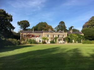 uma casa grande com um grande campo de relva em O'Harabrook Country House em Ballymoney