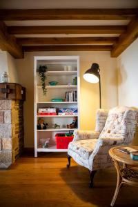 Una sala de estar con una silla y una estantería. en The Old Forge B&B, en Sark