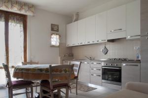 a kitchen with white cabinets and a table with chairs at Al centro della Toscana in Poggibonsi