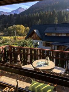 a wooden balcony with a table and chairs on it at La Casa di Carmen in Tarvisio