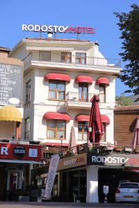 a white building with red umbrellas in front of it at Rodosto Hotel in Tekirdağ