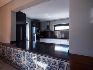 a kitchen with a large black and white counter top at Villa Caparica Hostel in Costa da Caparica