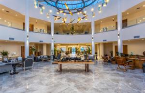 a lobby of a hotel with a table and chairs at Elysian Luxury Hotel and Spa in Kalamata