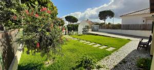 a garden with a fence and a grass yard at casa do vale - Lagoa de Albufeira in Lagoa de Albufeira