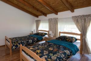a bedroom with two beds and a window at OPG HORVAT SOBE ZA ODMOR in Daruvar