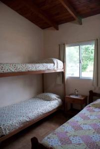 a bedroom with two bunk beds and a window at Cabañas Luz de Luna, Comuna San Roque-Punilla in Córdoba