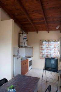 a kitchen with a refrigerator and a tv in it at Cabañas Luz de Luna, Comuna San Roque-Punilla in Cordoba