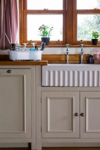 a kitchen counter with a sink and a window at The Old Forge B&B in Sark
