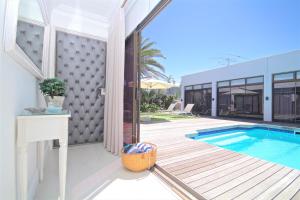 una casa con piscina y patio en OCEAN BREEZE SUNSET BEACH - Cape Town, en Ciudad del Cabo
