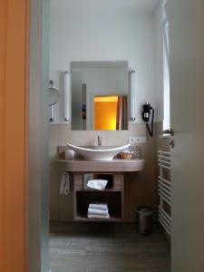 W łazience znajduje się umywalka i lustro. w obiekcie Hotel Restaurant Itzumer Paß w mieście Hildesheim
