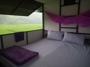 a bedroom with a bed with a large window at Samoeng fishing park home stay in Samoeng
