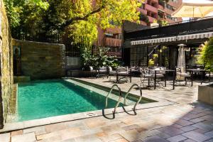 uma piscina com mesas e cadeiras num pátio em Wyndham Garden Santiago Kennedy em Santiago