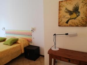 una camera con letto e foto di un uccello di Appartamento Silvana a Grosseto