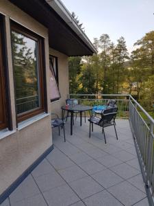 eine Terrasse mit einem Tisch und Stühlen auf dem Balkon in der Unterkunft Holiday House Radvanice in Radvanice