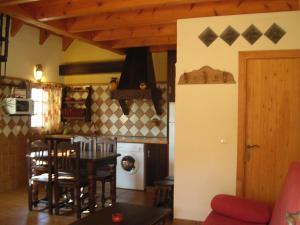 a kitchen with a table and chairs and a stove at Casas El Suspiro in Zahora