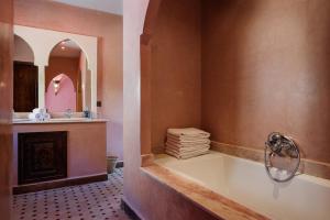 ein Badezimmer mit einer Badewanne, einem Waschbecken und einem Spiegel in der Unterkunft Le Village du Toubkal in Imlil