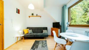 a living room with a couch and a table at Apartamenty Sun & Snow Moniuszki in Karpacz