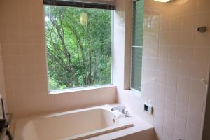 a bathroom with a bath tub and a window at Garden Villa Minamiaso in Minami Aso +45 photos
