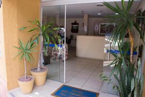 a lobby with two potted plants in a store at Hotel São Francisco in Águas de Lindóia