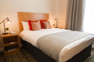 
a bed with a white comforter and pillows at Bannatyne Hotel Darlington in Darlington
