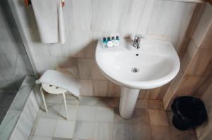 - Baño con lavabo blanco y ducha en White Nest Hostel, en Granada
