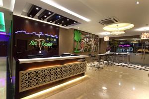 a restaurant with a bar with stools in a room at Sri Enstek Hotel KLIA, KLIA 2 & F1 in Sepang