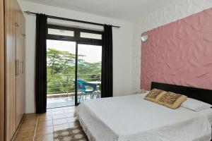 a bedroom with a bed and a large window at Joubarbe Residence in Moka