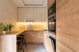 a kitchen with wooden cabinets and a counter with stools at Anna in Zagreb