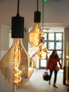 a woman standing in front of a group of light bulbs at Hotel Best Western City Centre in Brussels