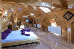 een slaapkamer met een groot bed in een houten kamer bij Wooden Attic Suite in Braşov