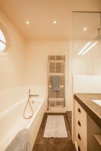 ein Badezimmer mit einer Badewanne und einem Waschbecken in der Unterkunft L'Annexe du Château in Annecy