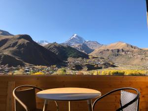a table and chairs on a balcony with mountains at Rustaveli st11 in Stepantsminda